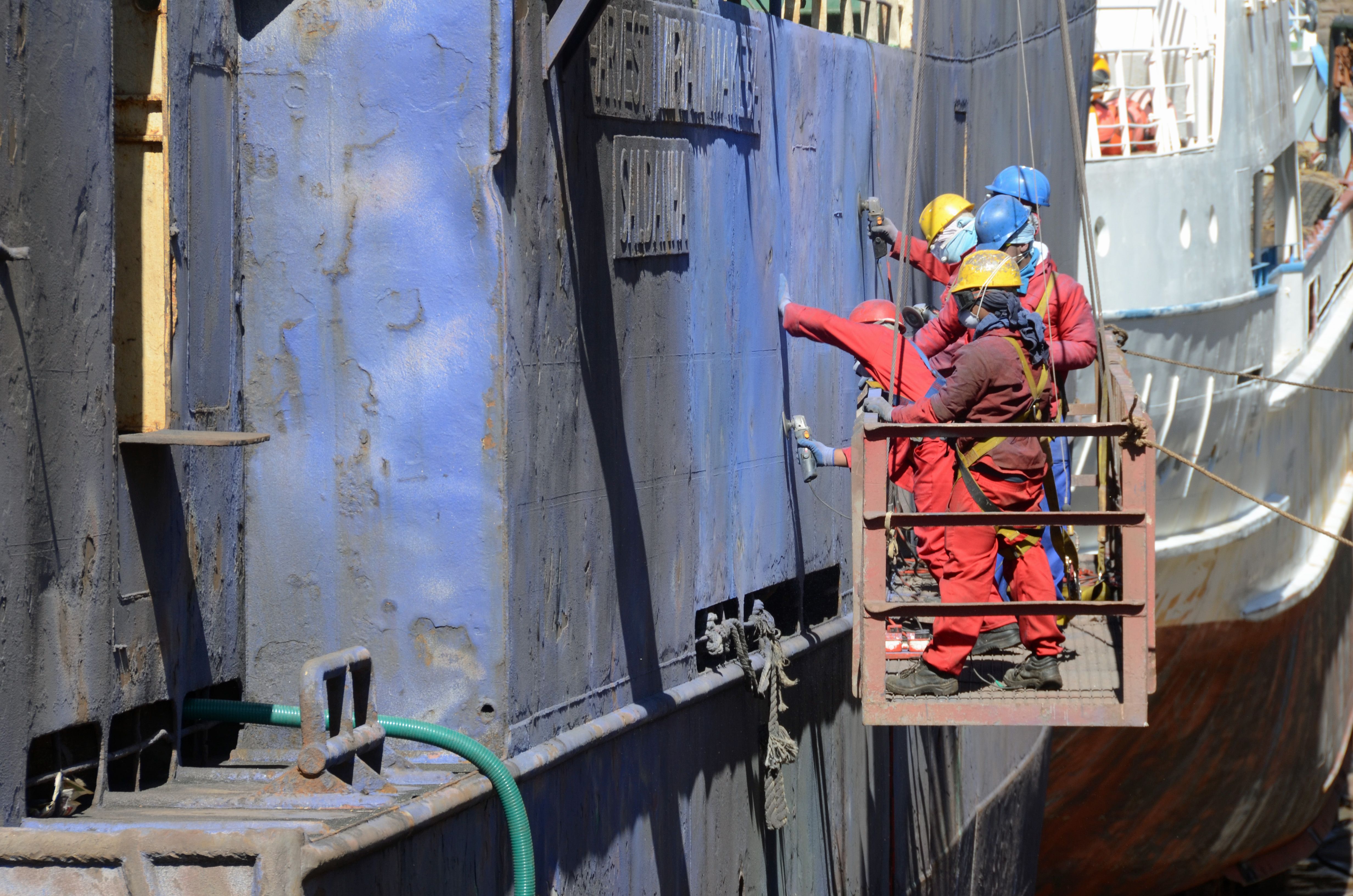 Crew and surveyor on a docked vessel